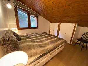 um quarto com uma cama grande e uma janela em Appartement Le Grand-Bornand, 2 pièces, 6 personnes - FR-1-241-186 em Le Grand-Bornand