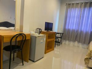 a room with a desk with a computer and a small refrigerator at Pupha Mansion in Chaweng Noi Beach