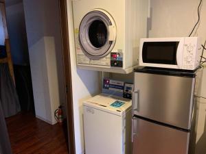 een magnetron bovenop een koelkast in een keuken bij Zenibako House 2f in Otaru