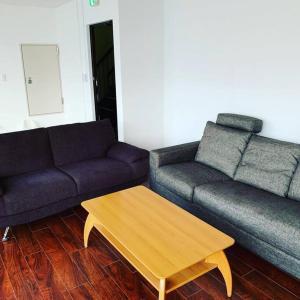 een woonkamer met twee banken en een salontafel bij Zenibako House 2f in Otaru +17 foto's