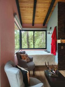 ein Wohnzimmer mit einer Badewanne und einem Stuhl in der Unterkunft Cabaña Nala de lujo para parejas in Mazamitla