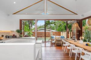 a kitchen and living room with a table and chairs at Espadrille Tres in Byron Bay
