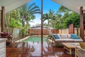 a patio with a couch and a swimming pool at Espadrille Tres in Byron Bay