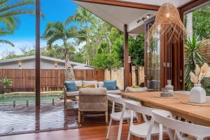 a patio with a table and chairs and a pool at Espadrille Tres in Byron Bay