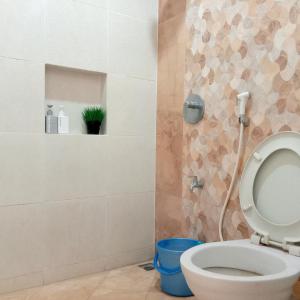 a bathroom with a toilet with a shower at Mutiara Balecatur Guest House in Yogyakarta