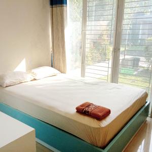 a bed in a room with a large window at Mutiara Balecatur Guest House in Yogyakarta