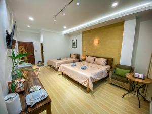 Muni Residence & Spa في باتامبانغ: غرفة نوم بسريرين واريكة وطاولة