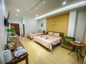Muni Residence & Spa في باتامبانغ: غرفة فندقية بسريرين واريكة