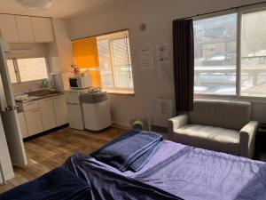 mały pokój z łóżkiem i kuchnią w obiekcie Zenibako House 3F-RoomB w mieście Otaru