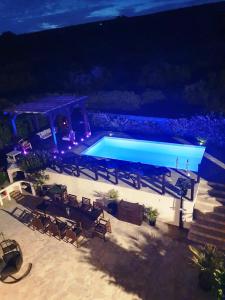 a swimming pool at night with chairs and a table at Villa Lavandina in Milna