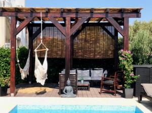 un pabellón de madera con hamaca y piscina en Villa Lavandina, en Milna