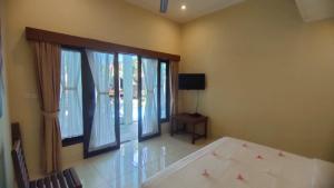 a bedroom with a bed and a room with windows at Lafayette House Canggu Bali in Canggu