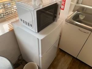 a microwave sitting on top of a white refrigerator at Zenibako House 3F-RoomD in Otaru