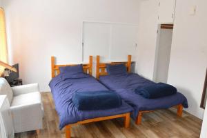 2 Betten mit blauen Kissen in einem Zimmer in der Unterkunft Zenibako House 3F-RoomD in Otaru