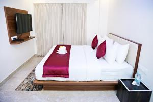 a hotel room with a bed and a tv at Villa Grand Hotel Near Kempegowda International Airport in Bangalore