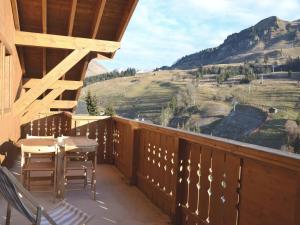 a balcony with a table and chairs and a mountain at Appartement Le Grand-Bornand, 4 pièces, 8 personnes - FR-1-391-3 in Le Grand-Bornand