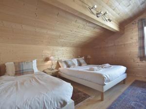 2 camas en una habitación con paredes de madera en Chalet Le Grand-Bornand, 5 pièces, 15 personnes - FR-1-391-24, en Le Grand-Bornand