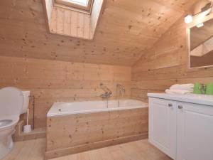 ein Holzbadezimmer mit einer Badewanne und einem WC in der Unterkunft Chalet Le Grand-Bornand, 5 pièces, 15 personnes - FR-1-391-24 in Le Grand-Bornand