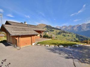 a house with a roof with mountains in the background at Chalet Le Grand-Bornand, 7 pièces, 10 personnes - FR-1-391-19 in Le Grand-Bornand