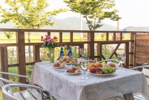 uma mesa com pratos de frutas e copos de vinho em Pension Hobak em Suncheon