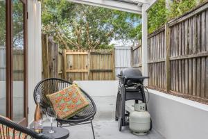 un caminante sentado en un porche junto a una valla en Espadrille Casita, en Byron Bay