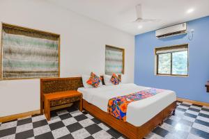 um quarto com uma cama e uma parede azul em FabExpress Coco Goa Resort With Pool, Arpora em Saligao