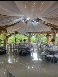 a wedding reception with tables and chairs under a tent at Hotel West California in Armenia +127 photos