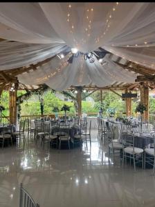 una recepción de boda con mesas y sillas bajo una tienda en Hotel West California, en Armenia