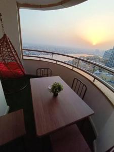 a table and chairs on a balcony with a view of the city at شقة فخمة وواسعة تسع عائلة كبيرة in Ajman 