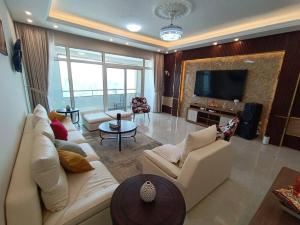 a living room with a white couch and a television at شقة فخمة وواسعة تسع عائلة كبيرة in Ajman 