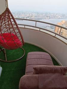 a chair and a couch on a balcony at شقة فخمة وواسعة تسع عائلة كبيرة in Ajman 