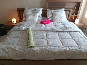 a white bed with a pink stuffed animal on it at شقة فخمة وواسعة تسع عائلة كبيرة in Ajman 