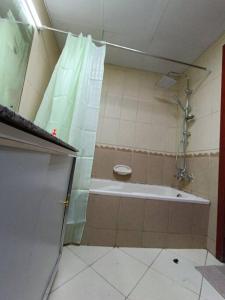 a bathroom with a shower and a bath tub at شقة فخمة وواسعة تسع عائلة كبيرة in Ajman 