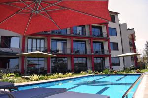 a hotel with a swimming pool and a red building at Mythos Boutique Hotel in Kigali