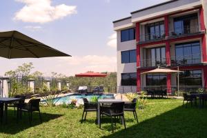 a patio with tables and chairs next to a building at Mythos Boutique Hotel in Kigali