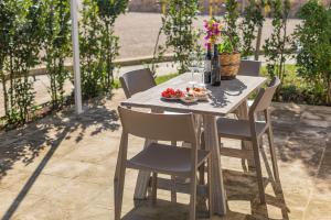 un tavolo con sedie e un piatto di cibo sopra di Agriturismo Vigna Corallo a Otranto
