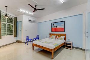 een slaapkamer met een bed en twee blauwe stoelen bij Capital O Elite Stay Jp Nagar Near SRI SATHYA GANAPATHI SHIRDI SAIBABA Temple in Bangalore