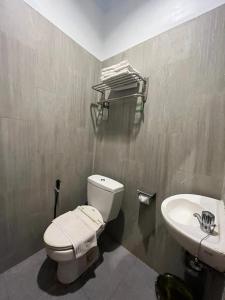 a bathroom with a toilet and a sink at Front One Green Boutique Hotel Abepura in Abepura