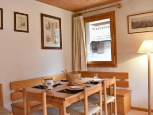 een eetkamer met een houten tafel en stoelen bij Appartement Méribel, 2 pièces, 5 personnes - FR-1-180-358 in Méribel