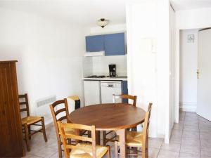 a kitchen with a wooden table and chairs in a room at Maison Duplex 6 Pers. avec Terrasse, Piscine Chauffée, Parking Gratuit - Vallon-Pont-d'Arc - FR-1-382-55 in Vallon-Pont-dʼArc