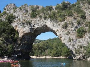 an arch in a rock formation in a body of water at Maison Duplex 6 Pers. avec Terrasse, Piscine Chauffée, Parking Gratuit - Vallon-Pont-d'Arc - FR-1-382-55 in Vallon-Pont-dʼArc