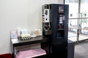 a soda machine in a room next to a table at le Lac Hotel Yokkaichi in Yokkaichi