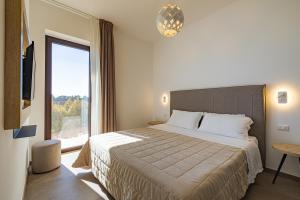 una camera con un grande letto e una grande finestra di Agriturismo Vigna Corallo a Otranto