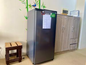 a stainless steel refrigerator in a room with a chair at Avida Aspira Condotel in Cagayan de Oro