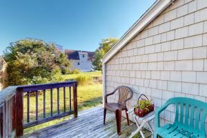 a porch with two chairs and a bench on it at Montgomery Cottage in Rockland