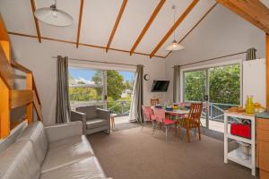 パウアヌイにあるPauanui Beach Therapy - Pauanui Holiday Homeのリビングルーム(ソファ、テーブル付)