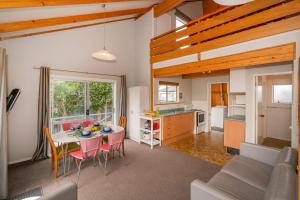 パウアヌイにあるPauanui Beach Therapy - Pauanui Holiday Homeのキッチン、リビングルーム(テーブル、椅子付)