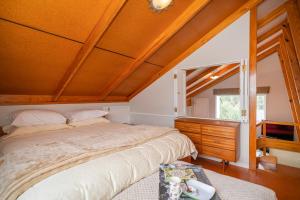 パウアヌイにあるPauanui Beach Therapy - Pauanui Holiday Homeの木製の天井のベッドルーム1室(大型ベッド1台付)