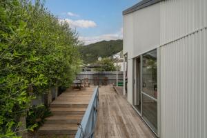 an external view of a house with a wooden deck at Pauanui Beach Therapy - Pauanui Holiday Home in Pauanui