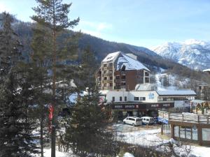 a building in the snow with cars parked in front at Studio au pied des pistes, 3 pers., Chantemerle - Serre Chevalier - FR-1-330E-99 in Serre Chevalier